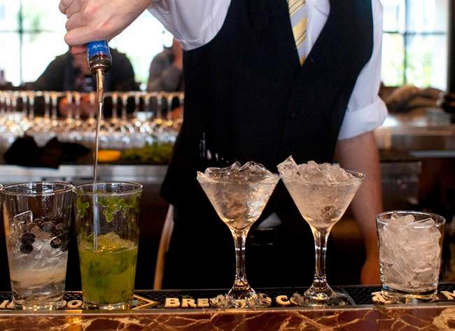 In this Monday, Nov. 19, 2012 file photo, a bartender prepares alcoholic drinks at a restaurant in San Francisco. Middle-aged men risk a faster mental decline as they age if they've been drinking heavily for years, new research suggests. 