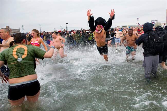 A first wave of swimmers jump into frigid waters at Coney Island beach in New York, Wednesday, Jan. 1 2014.