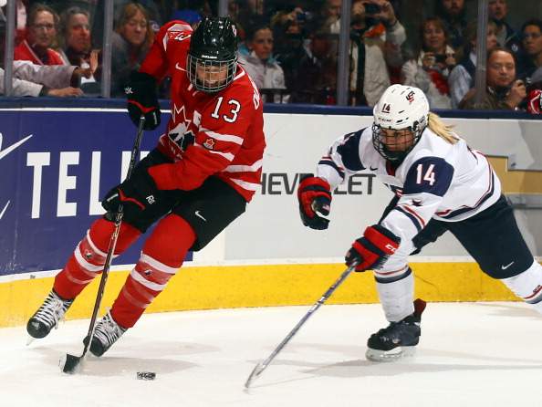 Caroline Ouellette #13 of Team Canada battles for the puck against Brianna Decker #13 of Team USA during a Sochi Olympics preparation game at the Air Canada Centre December 30, 2013 in Toronto.