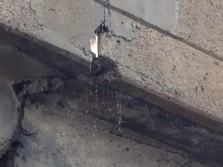 Cracks and holes allow water to pour off of the Henri-Bourassa overpass not far from falling concrete.