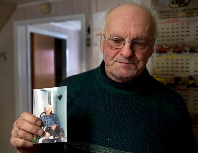 Jean-Andre Michaud holds a photo of his father, Paul-Etienne Michaud, 96, at his home Saturday, January 25, 2014 in L’Isle-Verte, Que. Michaud died in the fire at a seniors residence Thursday, Jan, 22, 2014. THE CANADIAN PRESS/Ryan Remiorz