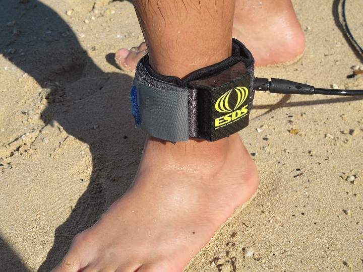 A surfer models a shark deterrent device, the Electronic Shark Defense System, in Honolulu on Dec. 17, 2013. 