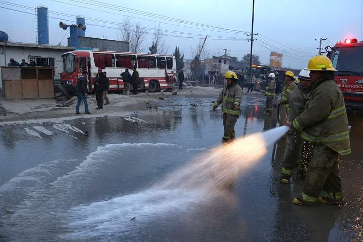 Afghan firefighters wash the street at the site of a suicide attack on a road in Kabul, Afghanistan, Sunday, Jan. 12, 2014. 
