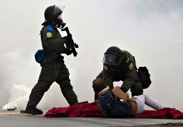 Provincial police officers confront protesters during a student demonstration outside the Quebec Liberal Party meeting Friday, May 4, 2012 Victoriaville, Quebec.