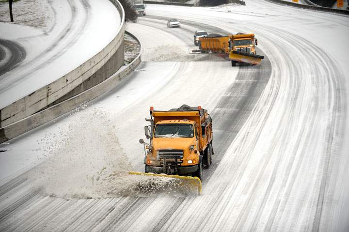 Snow plows clear downtown lanes on Interstate 75/85 during a winter storm on Wednesday, Feb. 12, 2014, in Atlanta.