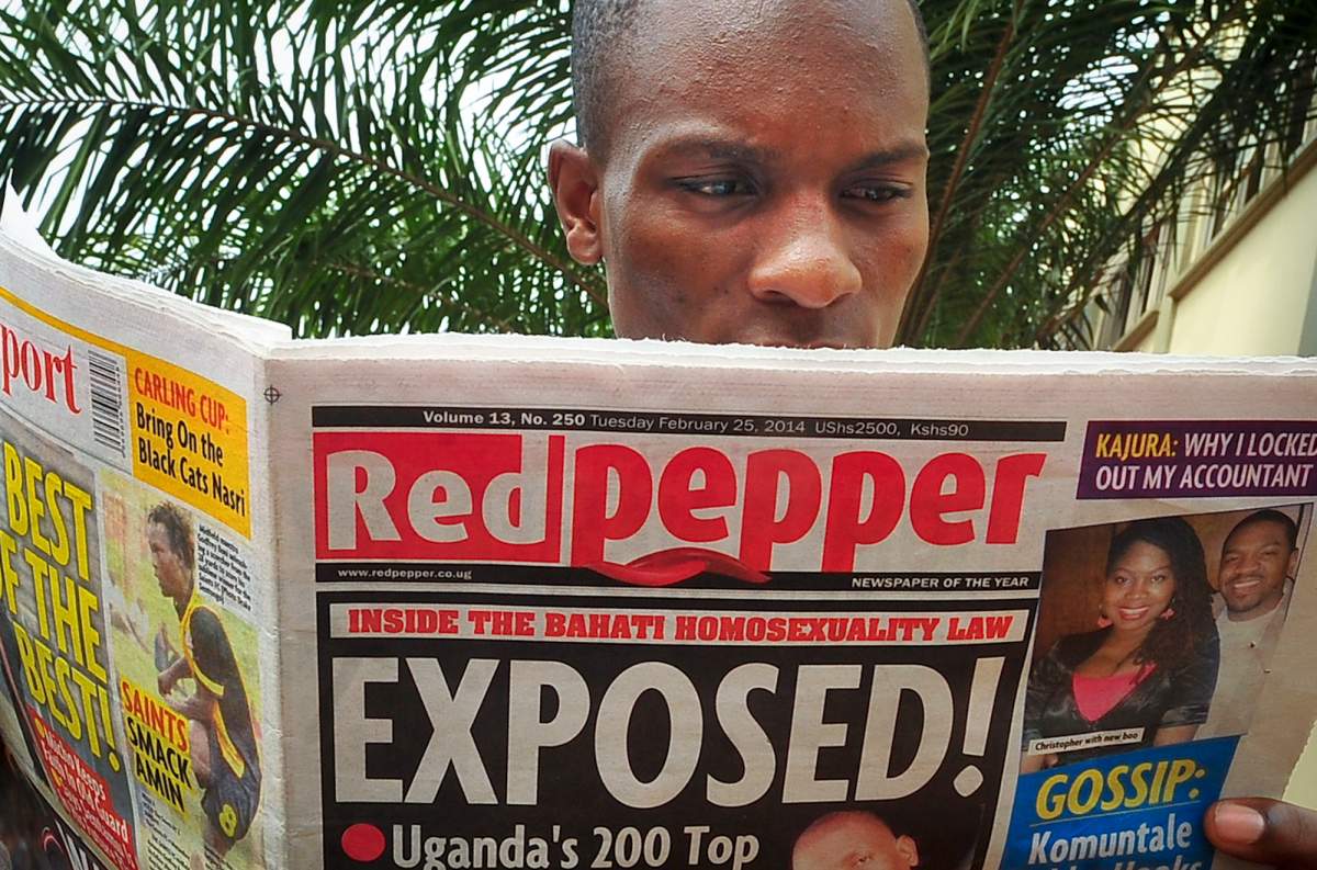 A Ugandan reads a copy of the "Red Pepper" tabloid newspaper in Kampala, Uganda Tuesday, Feb. 25, 2014.