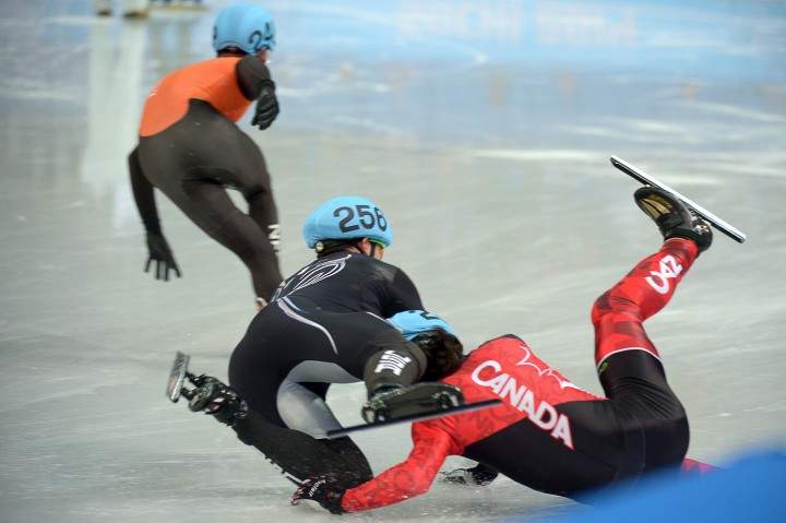 US Eduardo Alvarez (L) and Canada's Charles Hamelin crash and fall as they compete in the Men's Short Track 1000 m Quarterfinals at the Iceberg Skating Palace during the Sochi Winter Olympics on February 15, 2014. AFP PHOTO / DAMIEN MEYER .