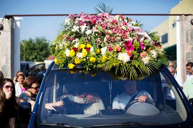 Relatives of Genesis Carmona, embrace inside the hearse carrying her body during her funeral, Friday, Feb. 21, 2014 in Valencia, Venezuela.