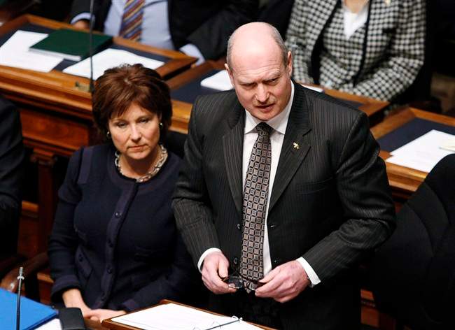 Premier Christy Clark (left) listens as B.C. Finance Minister Mike de Jong tables the provincial budget in the Legislative Assembly Tuesday, February 18, 2014 in Victoria, B.C. THE CANADIAN PRESS/Chad Hipolito.