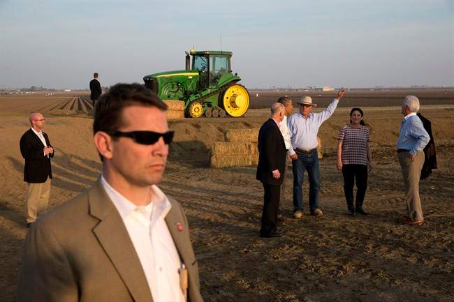 President Barack Obama, second from left in group, tours a local farm with Governor Jerry Brown, left, Joe Del Bosque of Empresas Del Bosque, Inc., and Maria Gloria Del Bosque also of Empresas Del Bosque, Inc.,and Rep. Jim Costa, D-Calif., in Los Banos, Calif., Friday, Feb. 14, 2014, where he spoke about the drought. (AP Photo/Jacquelyn Martin).