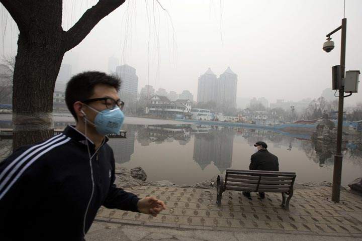 A man jogs while wearing a mask during a day of heavy pollution in Beijing, China, Monday, Feb. 24, 2014. (AP Photo/Ng Han Guan)