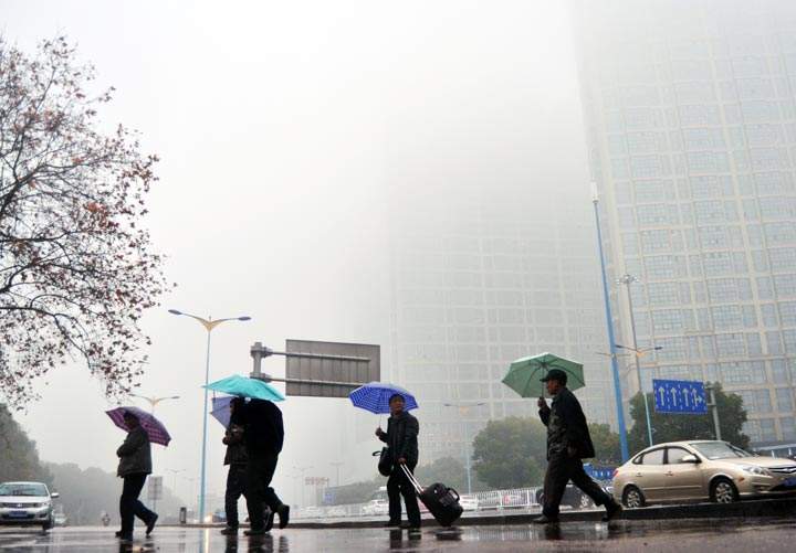 People holding umbrella walk in the haze on February 24, 2014, in Changsha, Hunan Province of China. (ChinaFotoPress/Getty Images)