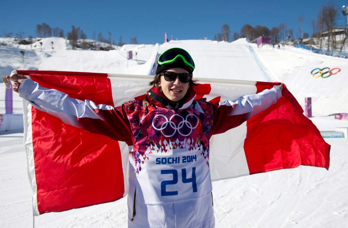 Mark McMorris of Canada waves the Canadian flag after winning a bronze medal in the men’s slopestyle snowboard final. (Jonathan Hayward/The Canadian Press)