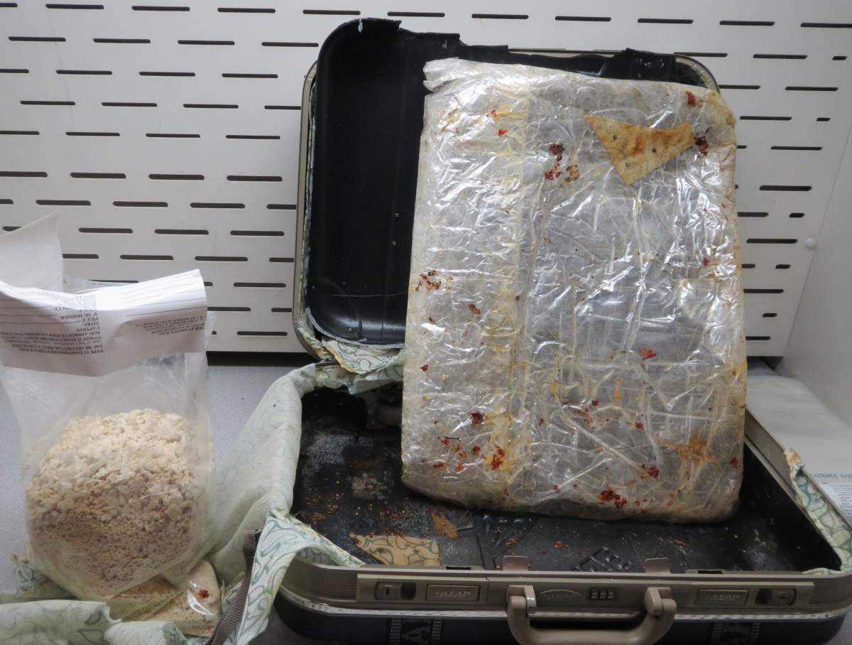 Seized suspected heroin and false-bottom suitcases used to conceal the narcotics.
