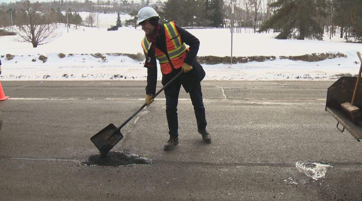 Mayor Don Iveson pitched in and helped fill a pothole Friday afternoon.