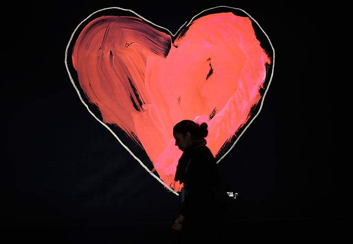A woman passes a billboard as she arrives at the Mercedes-Benz Fashion Week Fall/Winter 2014 shows February 6, 2014 in New York City.