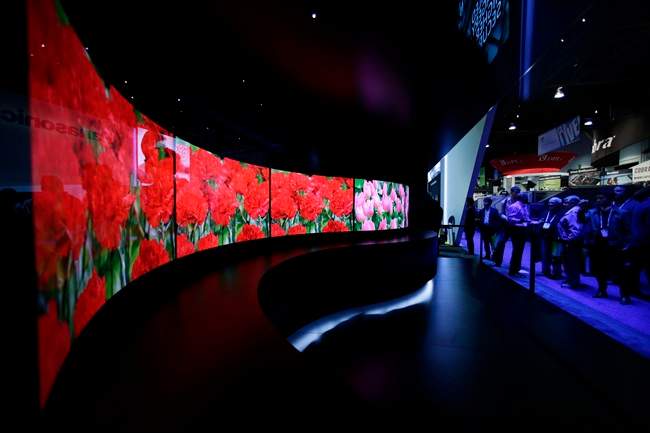 In this Jan. 7, 2014 file photo, attendees looks at the installation made with curved OLED displays at the Panasonic booth during the International Consumer Electronics Show in Las Vegas. Panasonic reports quarterly earnings on Tuesday, Feb. 4, 2014.