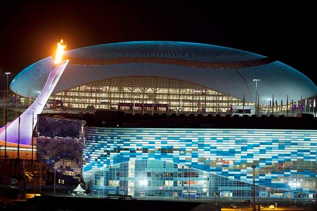  In this Thursday, Feb. 6, 2014 file photo, the Olympic cauldron, left, is lit during a test between the Bolshoy Ice Dome, top, and the Iceberg Skating Palace, foreground, in Sochi, Russia, prior to the start of the 2014 Winter Olympics. 