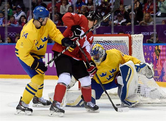 Canada forward Jonathan Toews scores past Sweden goaltender Henrik Lundqvist as Patrik Berglund looks on during first period men's gold medal final hockey action at the Sochi Winter Olympics Sunday, February 23, 2014 in Sochi.