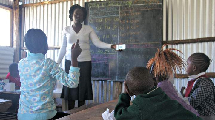 A teacher uses a smartphone to conduct vision test on students at a school in Kenya.