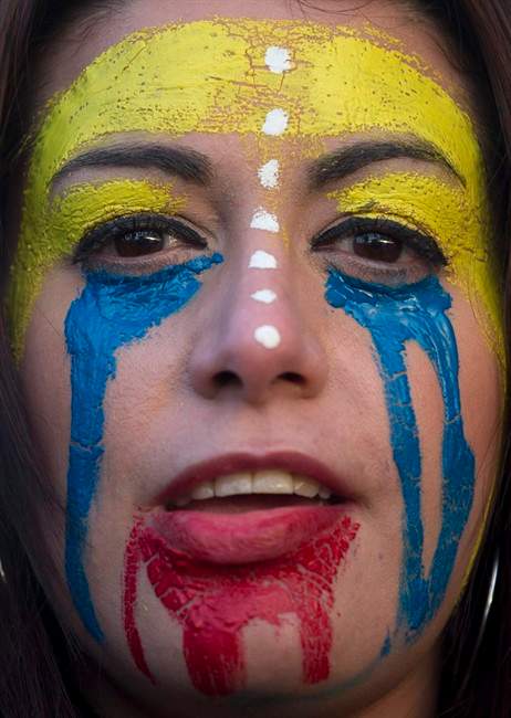 A woman with her face painted with the colors of the Venezuelan flag protests against the Venezuelan government in Madrid, Spain, Tuesday, Feb. 18, 2014.