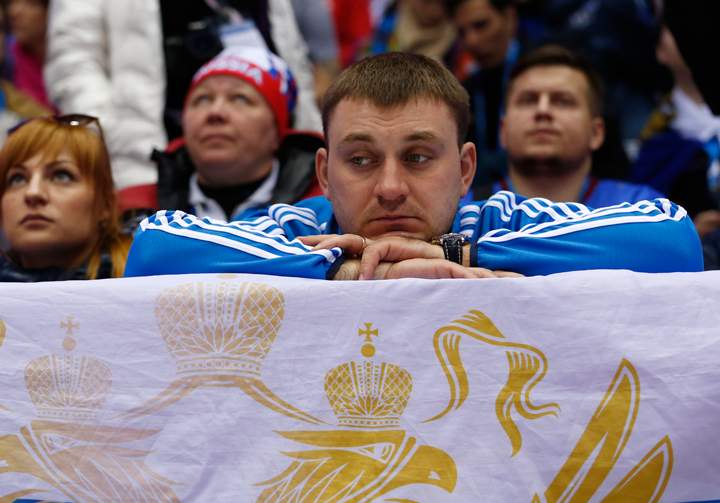 Russian hockey fans watch play against Finland in the third period of a men’s quarterfinal ice hockey game at the 2014 Winter Olympics, on Feb. 19, 2014, in Sochi, Russia. (Photo credit: AP Photo/Julio Cortez)