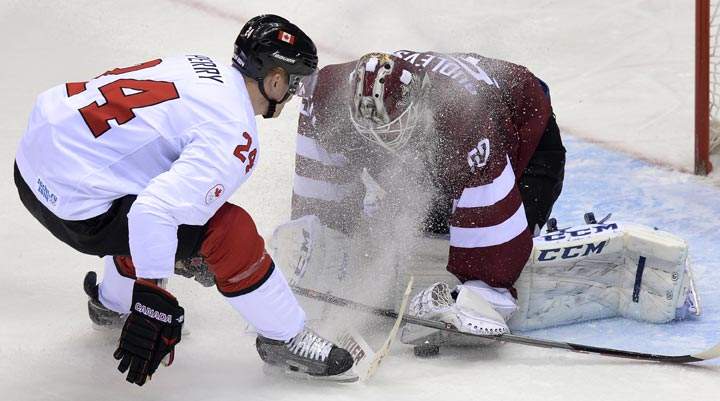 Canada’s Corey Perry attacks Latvia’s goalkeeper Kristers Gudlevskis during the Men’s Ice Hockey Quarterfinals Canada vs Latvia at the Bolshoy Ice Dome during the Sochi Winter Olympics on February 19, 2014. (Alexander Nemenov/AFP/Getty Images)