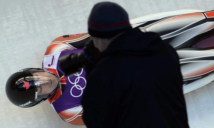 A photographer shoots an image of Canada’s Sam Edney during a practices run at the men’s Luge training session at the Sanki Sliding Centre in Rosa Khutor on February 6, 2014. (Lionel Bonaventure/AFP/Getty Images)