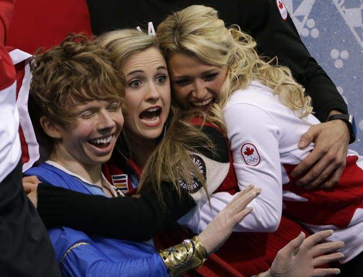 Kevin Reynolds of Canada, left, and team members react as he sits in the results area after competing in the men’s team free skate figure skating competition at the Iceberg Skating Palace during the 2014 Winter Olympics, Sunday, Feb. 9, 2014, in Sochi, Russia. (AP Photo/David J. Phillip )