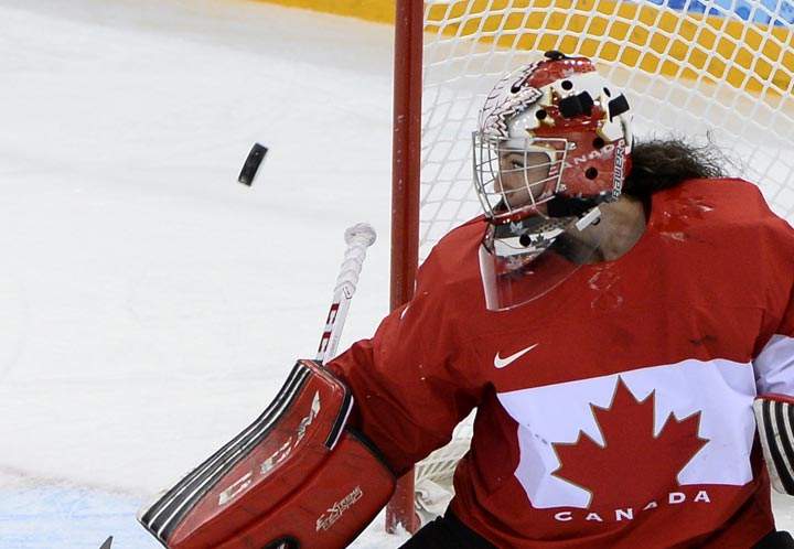The puck flies past Canada's goalkeeper Shannon Szabados during the Women's Ice Hockey Group A match Finland vs Canada at the Shayba Arena during the Sochi Winter Olympics on February 10, 2014. (Jonathan Nackstrand/AFP/Getty Images).