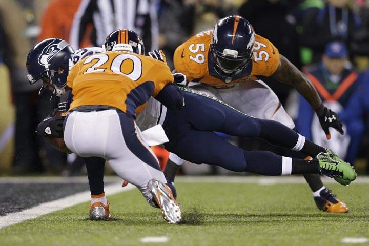Seattle Seahawks’ Doug Baldwin dives between Denver Broncos’ Mike Adams, left, and Danny Trevathan for a touchdown during the second half of the NFL Super Bowl XLVIII football game Sunday, Feb. 2, 2014, in East Rutherford, N.J. (AP Photo/Julio Cortez)