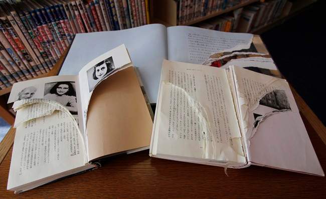 Ripped copies of Anne Frank's "Diary of a Young Girl" and related books are shown at Shinjuku City Library in Tokyo Friday, Feb. 21, 2014. Tokyo Libraries said on Friday that hundreds of copies of Anne Frank's diary and related books have been found vandalised across the city's libraries in the last month, sparking fears of an anti-Semitic motive. A total of 265 books in 31 libraries had been found damaged after the first damaged book was found in January, prompting a wider search. (AP Photo/Koji Ueda).