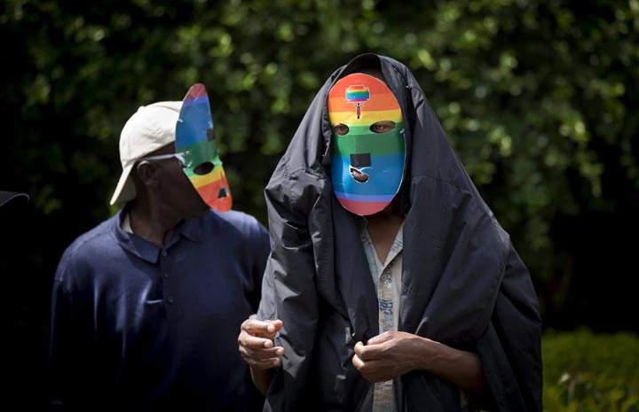 Kenyan gays and lesbians and others supporting their cause wear masks to preserve their anonymity as they stage a rare protest against Uganda's increasingly tough stance against homosexuality and in solidarity with their counterparts there, outside the Uganda High Commission in Nairobi, Kenya Monday, Feb. 10, 2014.