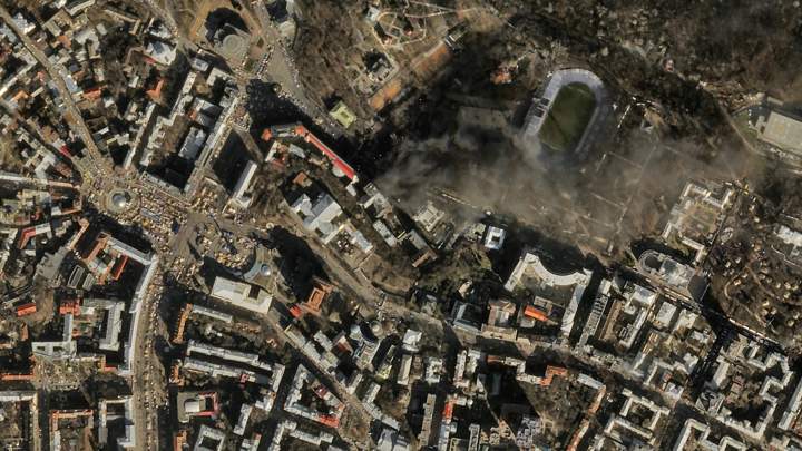 In this satellite image provided by Skybox Imaging and taken by SkySat-1 on Tuesday, Feb. 18, 2014 at 11:10 a.m. local time, smoke rises from the site of anti-government protests, upper center, in Kyiv, Ukraine. (Photo credit: Skybox Imaging/AP Photo)