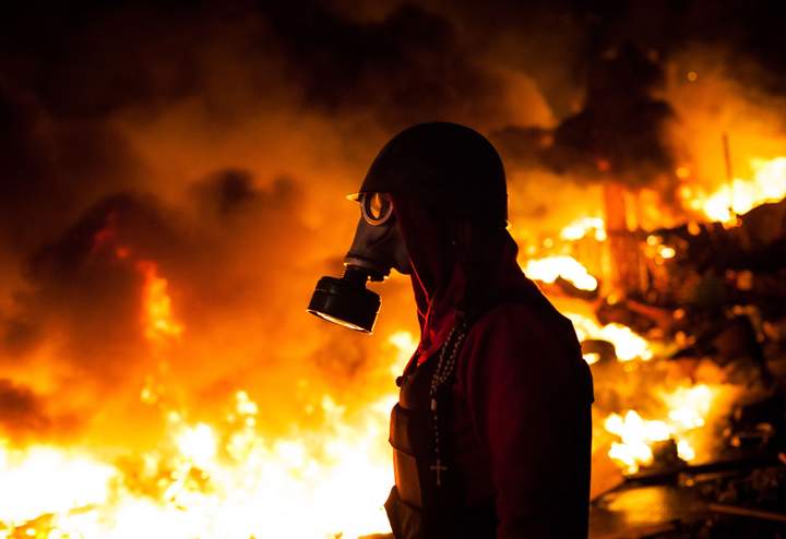 Flames engulf the main anti-government protest camp on Independence Square on Feb. 18, 2014 as riot police tried to force demonstrators out Anti-government protest in Kyiv, Ukraine. (Photo credit: Emeric Fohlen/AP Photo)