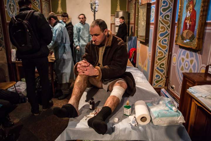An injured anti-government protester awaits treatment at the Mikhailovsky Monastery, which has been converted into a makeshift hospital, on February 19, 2014 in Kyiv, Ukraine. (Photo credit: Brendan Hoffman/Getty Images)