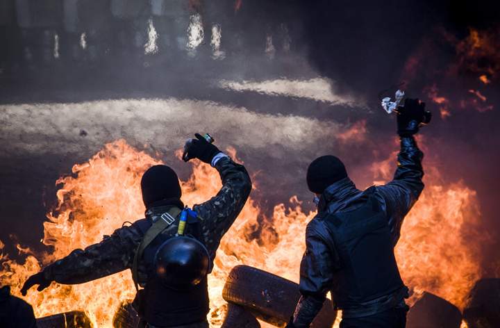 Anti-government demonstrators clash with riot police in central Kyiv on Feb. 18, 2014. Opposition leader Vitali Klitschko on February 18 urged women and children to leave the opposition’s main protest camp on Kiev’s Independence Square, known as Maidan, as riot police massed nearby. (Photo credit: Sandro Maddalena)