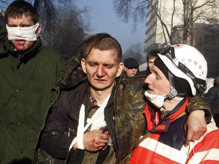 Anti-government protesters carry a wounded man during clashes with riot police in Kyiv on Feb. 18, 2014. (Photo credit: Yury Kirnichny/Getty Images)