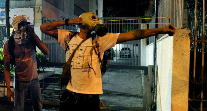 Protesters confront riot policemen during an anti-government demo, in Caracas on February 19, 2014.