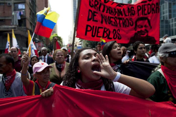Members of a pro-government "colectivo," or "collective," march in downtown Caracas, Venezuela, Thursday, Feb. 20, 2014. President Nicolas Maduro and his supporters say the escalating protests against his socialist government in the oil-rich but economically struggling country are part of an attempted coup sponsored by right-wing and "fascist" opponents in Venezuela and abroad, particularly the United States. 