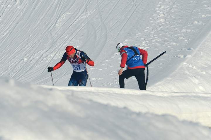 Russia’s Anton Gafarov is helped by Canada’s cross-country coach Justin Wadsworth after crashing in the men’s cross-country skiing sprint free semifinals during the Sochi Winter Olympics on February 11, 2014 in Rosa Khutor near Sochi. Wadsworth was applauded for showing the true spirit of the Olympics when he helped Gafarov to finish after breaking a ski in a crash.