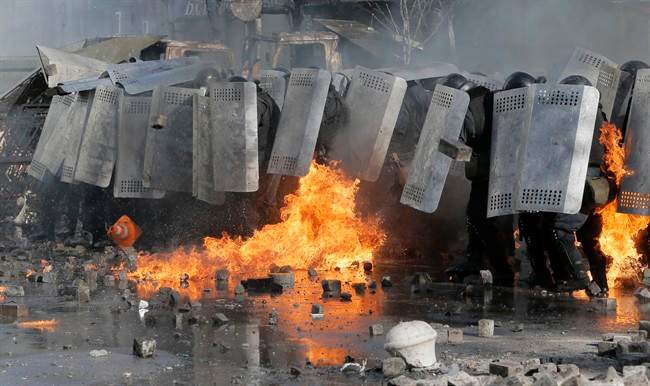 Riot police clash with anti-government protesters outside Ukraine’s parliament in Kyiv, Ukraine, Tuesday, Feb. 18, 2014.