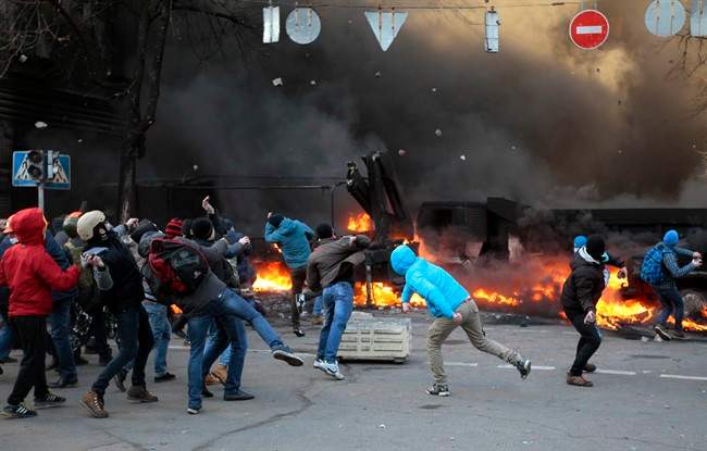 Anti-government protesters clash with riot police outside Ukraine’s parliament in Kyiv, Ukraine, Tuesday, Feb. 18, 2014. Ukraine’s festering political crisis took a deadly turn Tuesday, as thousands of anti-government protesters clashed with police outside Ukraine’s parliament.