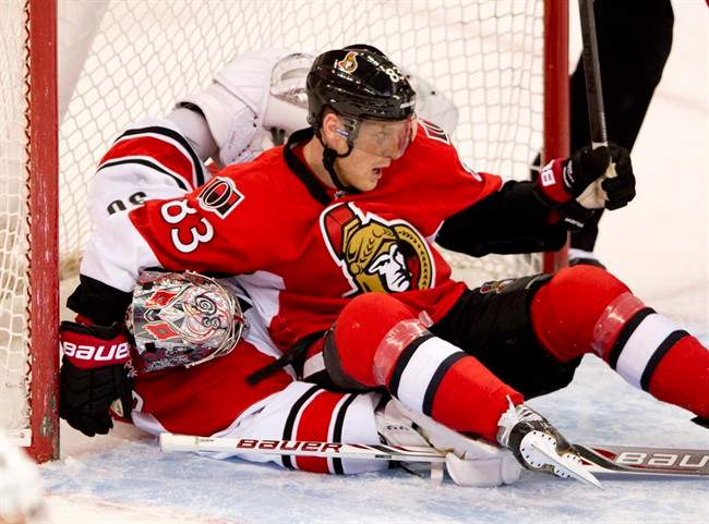 Ottawa Senators Ales Hemsky lies on top of Carolina Hurricanes goalie Cam Ward during first period NHL action Monday March 31, 2014 in Ottawa.
