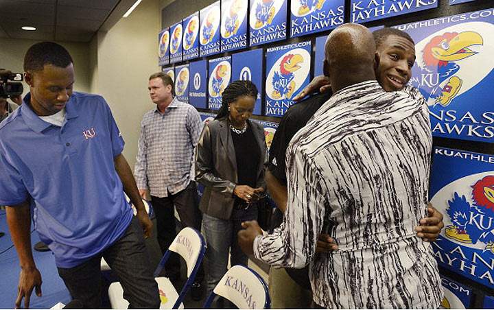 After a press conference on March 31, 2014, Kansas freshman basketball star, Andrew Wiggins, facing right, gets a hug from his dad Mitchell.