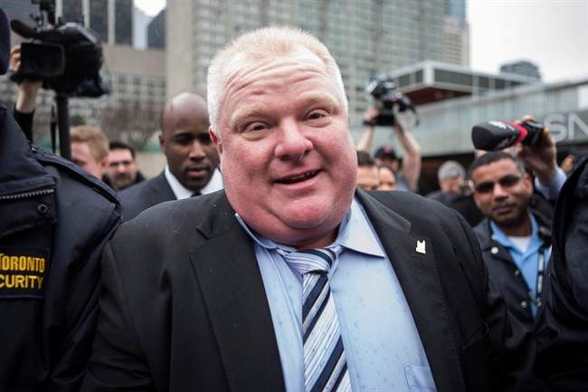Toronto Mayor Rob Ford is pursued by the media outside city hall