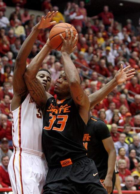 Oklahoma State guard Marcus Smart draws a foul on Iowa State forward Melvin Ejim as he drives to the basket during the second half of an NCAA college basketball game in Ames, Iowa, Saturday, March 8, 2014.