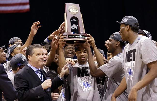 Kentucky's Aaron Harrison and his teammates hold up their trophy after an NCAA Midwest Regional final college basketball tournament game against Michigan Sunday, March 30, 2014, in Indianapolis.