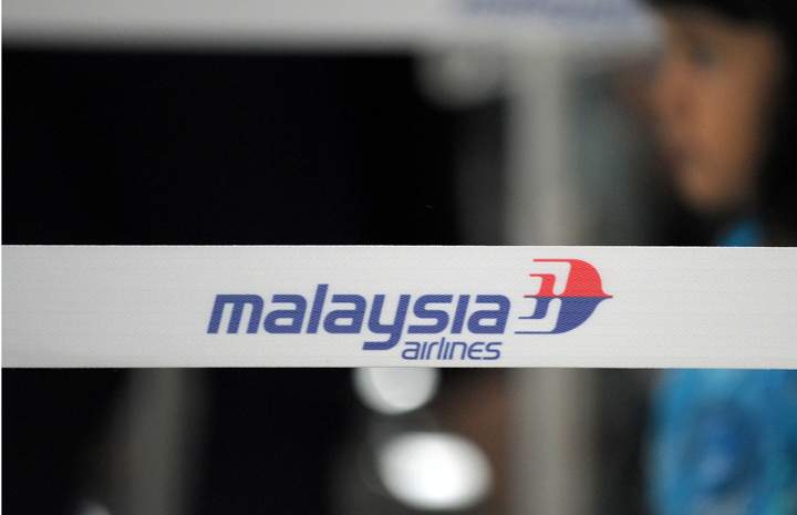 A girl walks past a Malaysian Airlines logo (MAS) at the Kuala Lumpur International Airport (KLIA) in Sepang, outside Kuala Lumpur on March 9, 2014. 