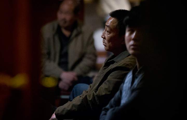 Relatives of Chinese passengers aboard missing Malaysia Airlines flight MH370 watch a TV news program about searching of the missing flight.